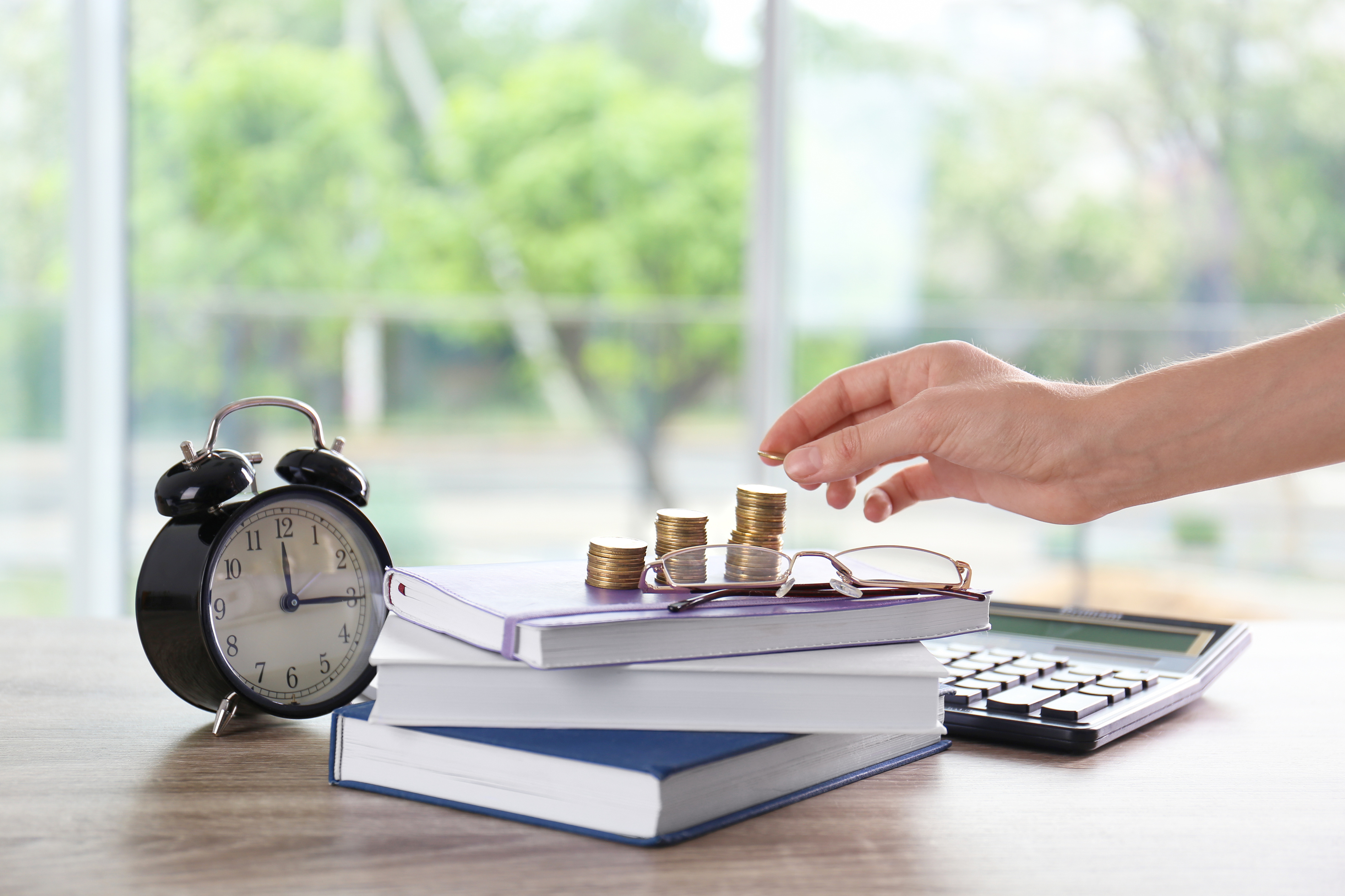 Woman Stacking Coins on Table. Tax Calculation